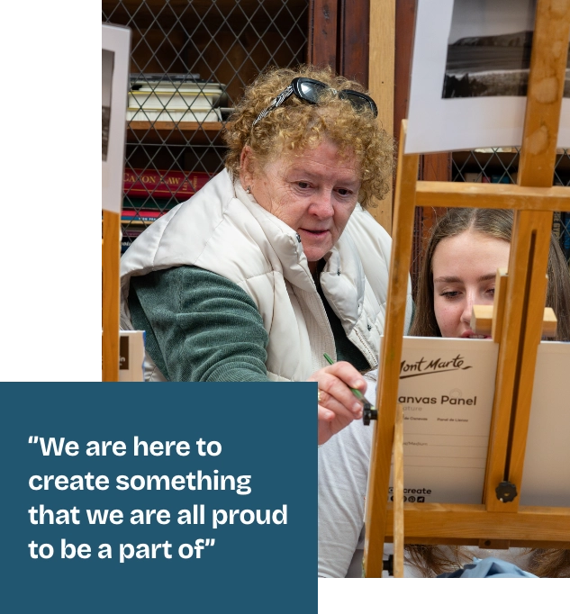 A person with curly hair and a white vest participates in a painting activity with another person. They are focused on a canvas. A quote on the image reads, "We are here to create something that we are all proud to be a part of".